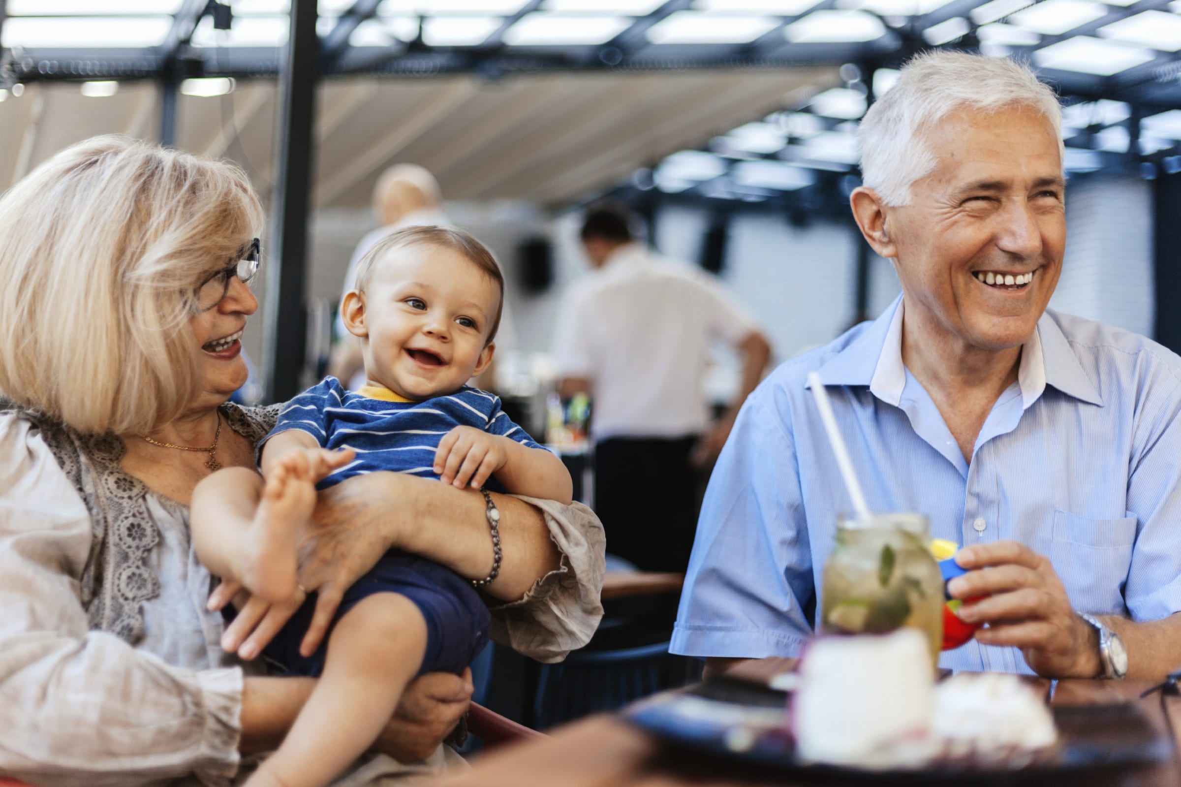 Grandparents With Their Grandson Spending Lovely Time At Cafe