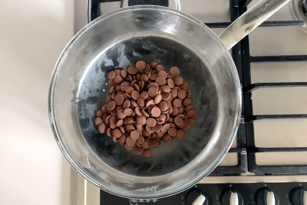 Chocolate drops in a heat-proof bowl over a pan of simmering water