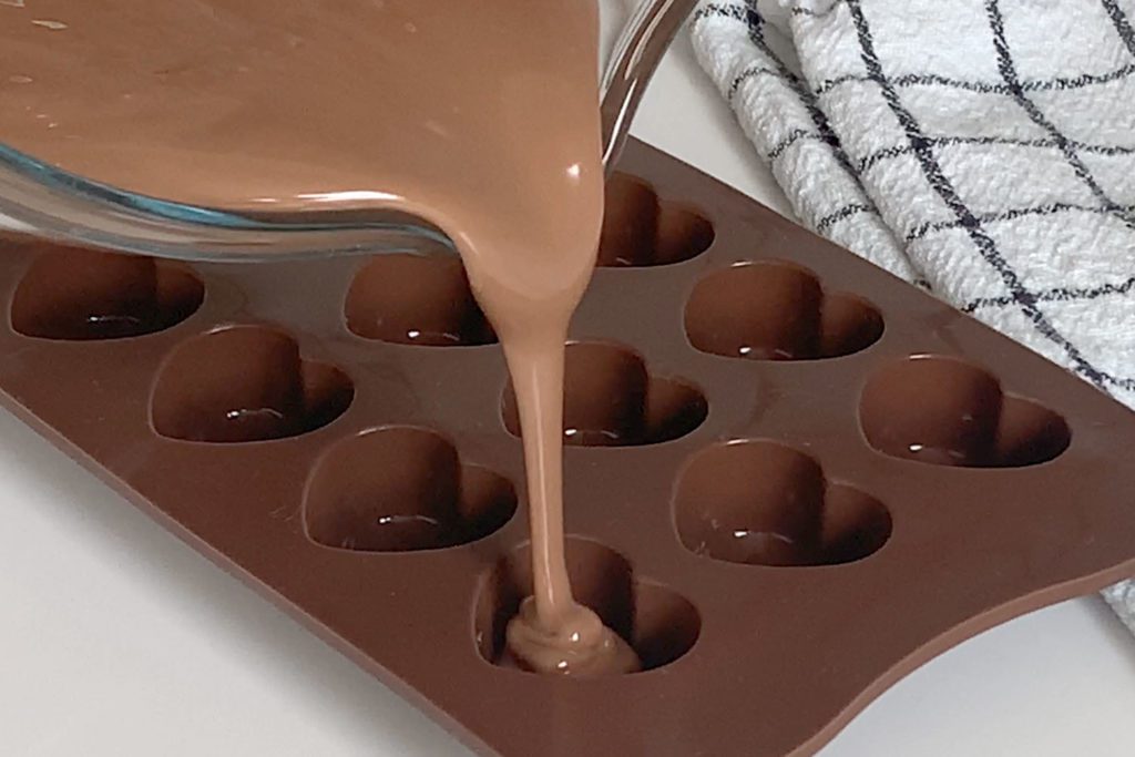 Tempered chocolate being poured into a silicon mould